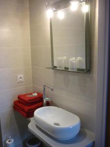 W łazience znajduje się biała umywalka i lustro. w obiekcie L'envers du Castille w mieście Parthenay