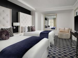 una habitación de hotel con dos camas y una silla en Sofitel Lafayette Square Washington DC, en Washington