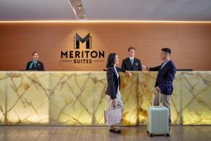 a group of people standing in front of a merion services counter at Meriton Suites Campbell Street, Sydney in Sydney +18 photos