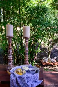 einen Tisch mit zwei Kerzen und einem Teller Essen in der Unterkunft Peaceful off-grid stay surrounded by nature in Traveston