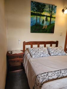 a bedroom with two beds and a painting on the wall at Esquina Apart in Esquina +35 photos