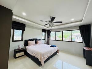 a bedroom with a bed and a ceiling fan at Bangsaen sansuk in Ban Laem Thaen