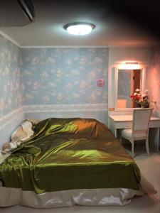 a bedroom with a bed and a desk and a window at Bangsaen sansuk in Ban Laem Thaen