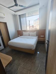 a bed in a room with a large window at Hotel Elev11 in Zirakpur