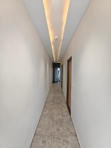 a corridor in a building with white walls and a long hallway at Hotel Elev11 in Zirakpur