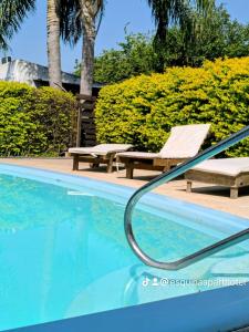 a swimming pool with a chair and a bench at Esquina Apart in Esquina