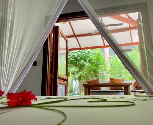 a bedroom with a bed with a red flower on it at Baobab Bungalows in Jambiani