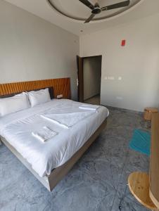 a bedroom with a large white bed with a ceiling at Hotel Elev11 in Zirakpur