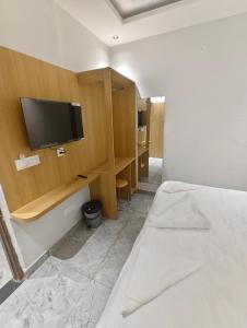 a bedroom with a bed and a tv on a wall at Hotel Elev11 in Zirakpur +5 photos