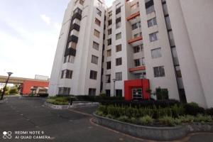 a large white apartment building with a parking lot at Comfortable apartment in South Quito in Quito