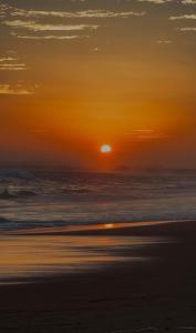 a sunset on a beach with the ocean at Rekawa Turtle Gate Hotel in Tangalle