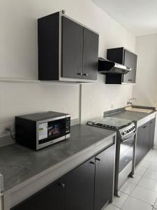 a kitchen with a microwave sitting on a counter at Comfortable apartment in South Quito in Quito