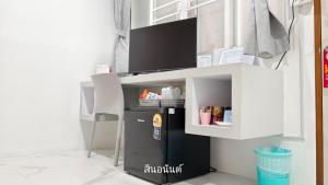 バンバンセーンにあるสินอนันต์ อพาร์ทเม้นต์Sinanan apartmentの部屋には小さな冷蔵庫付きの机がある
