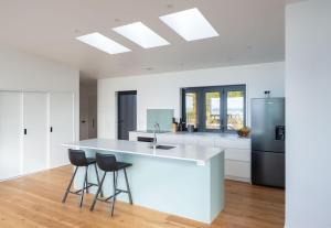 カイテリテリにあるKokomeaのキッチン(白いカウンター、スツール2脚付)