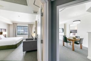 a hotel room with a bed and a desk at Darwin Harbourside Escape - Two Adjacent King Suites in Darwin