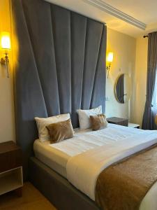 a bedroom with a large bed with a large headboard at Maas Nightingale Apartments in Port Harcourt