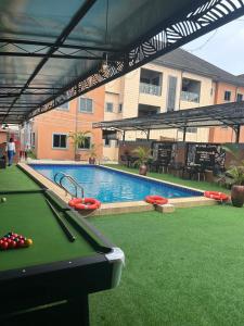 a pool table in a yard with a swimming pool at Maas Nightingale Apartments in Port Harcourt