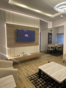 a living room with a flat screen tv on a wall at Maas Nightingale Apartments in Port Harcourt +13 photos