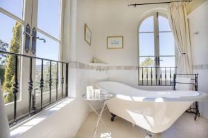 a bath tub in a bathroom with a balcony at Villa Howden in Margate