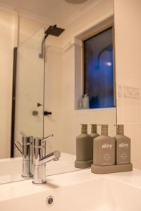 a bathroom sink with two soap bottles on it at Sorell Gateway Villa in Sorell