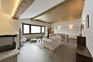 Una sala de estar con muebles blancos y chimenea. en Attic Lake View with Free Parking, en Silvaplana