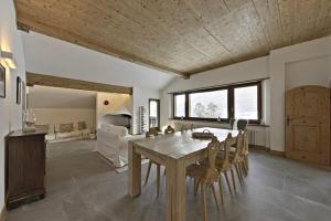 Un comedor con mesa y sillas de madera. en Attic Lake View with Free Parking, en Silvaplana