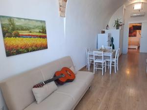 a living room with a couch with a guitar on it at A Levante in Putignano