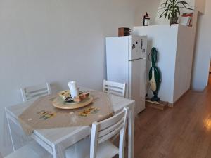 a kitchen with a white table and a white refrigerator at A Levante in Putignano
