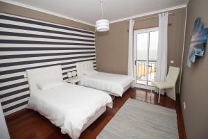 ポンタ・デルガダにあるOliveira's Apartments - Madeira Islandのベッドルーム1室(ベッド2台付)が備わります。