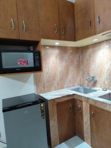 a kitchen with a microwave and a sink at Best Eastern Apartment in Dhaka +5 photos
