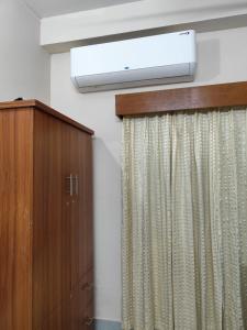 a room with a television and a curtain at Best Eastern Apartment in Dhaka