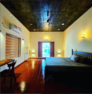 a bedroom with a bed and a ceiling with a fan at Acrewood Farmhouse - Pool Villa in Vāzhākulam