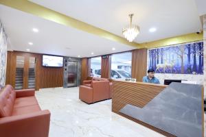 Een man aan een balie in een lobby. bij Hotel Arctic Gold in Cochin