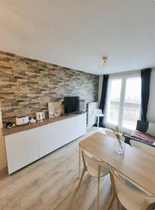 ein Wohnzimmer mit einem Tisch und einer Ziegelwand in der Unterkunft Chambre Privée Cosy- Dans Appartement Moderne en Colocation- Tram A -P5-2 in Lormont
