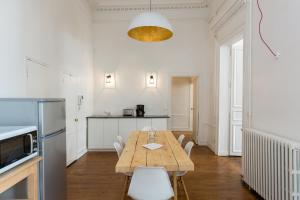 a kitchen and dining room with a wooden table and chairs at Opéra Septembre in Paris