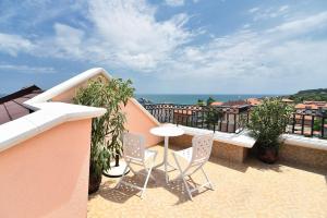 a balcony with a table and chairs and the ocean at Sirena Palace Family Hotel in Obzor