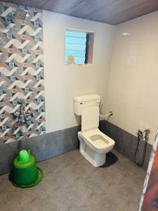 Un baño con inodoro y ventana. en Coastal Home, en Diveagar