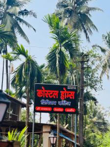Un cartel en una calle con palmeras al fondo. en Coastal Home, en Diveagar