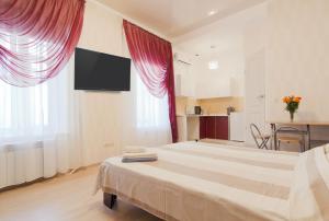 a bedroom with a large bed with a tv on the wall at Best Apartment in the city centre in Odesa