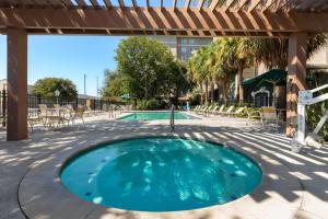 an outdoor swimming pool with a pergola at La Quinta by Wyndham San Antonio Airport in San Antonio