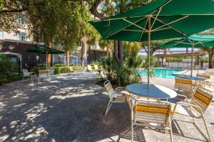 a patio with tables and chairs with green umbrellas at La Quinta by Wyndham San Antonio Airport in San Antonio +31 photos
