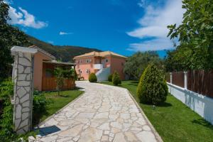 a stone walkway in a yard with a house at Eleana Studios in Lefkada +19 photos