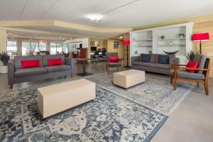 a living room with couches and chairs and a table at Wingate by Wyndham Lincoln Airport East I-80 in Lincoln