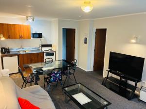 Una sala de estar con un sofá y una mesa con televisión. en Awatea Park Motel, en Palmerston North 22 fotos más