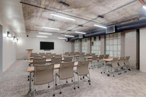 a conference room with tables and chairs and a tv at Reside Houston Downtown, a Wyndham Residence in Houston