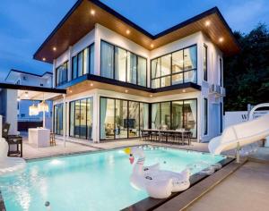 une maison avec une piscine devant une maison dans l'établissement Walters House Pool Villa Pattaya, à Ban Huai Yai
