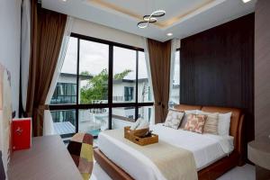 une chambre avec un lit et une grande fenêtre dans l'établissement Walters House Pool Villa Pattaya, à Ban Huai Yai 90 autres photos