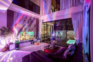 un salon avec un canapé et une télévision dans l'établissement Walters House Pool Villa Pattaya, à Ban Huai Yai