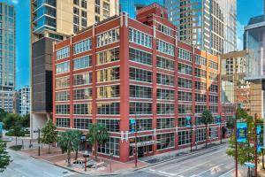 a red building in a city with tall buildings at Reside Houston Downtown, a Wyndham Residence in Houston