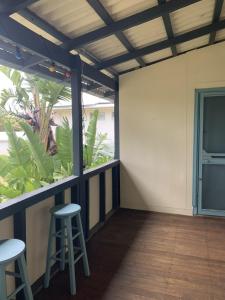 a patio with two stools and a plant at The Beach Cottage - close to beach and river mouth in Guilderton